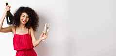 快乐女人聚会情人节一天假期跳舞玻璃瓶香槟穿红色的衣服微笑白色背景