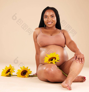 <strong>黑色</strong>的女人坐着花怀孕了微笑肖像美<strong>护肤品</strong>孤立的工作室背景怀孕发光妈妈。自然自然化妆品护理健康健康