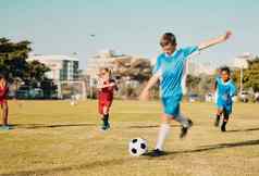 足球男孩运行踢球场夏天动机体育锻炼目标足球团队合作增长孩子们玩游戏草足球场城市公园孩子们团队