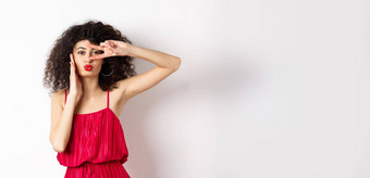 美时尚时尚的卷发女人红色的衣服显示地摆眼睛皱纹嘴唇接吻站白色背景