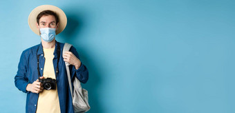科维德旅行概念年轻的的家伙旅游医疗面具夏天他旅行在国外冠状病毒流感大流行采取图片假期蓝色的背景
