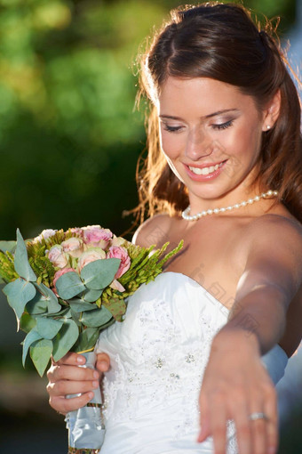 让跳舞美丽的年轻的新娘持有花束手令人心动的相机