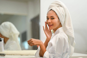 快乐的千禧女人浴袍站前面镜子日常例程首页