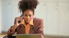 年轻的非洲办公室工人移动PC屏幕会说话的移动电话争论客户端客户