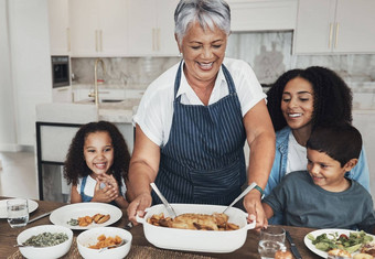 祖母家庭首页孩子们表格食物午餐庆祝活动爱护理幸福黑色的人高级女人孩子们晚餐聚会，派对快乐成键厨房