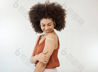 年轻的拉美裔混合比赛女人穿<strong>邦迪</strong>牌创可贴手臂站白色工作室背景快乐女人卷曲的非洲式发型石膏手臂白色背景