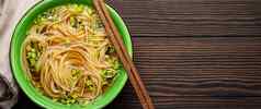 亚洲面条汤绿色乡村陶瓷碗木筷子前视图黑暗木背景我的面条肉汤绿色洋葱