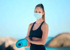 美丽的女人瑜伽锻炼穿面具年轻的女运动员站海滩工作停止传播电晕病毒练习安全科维德限制