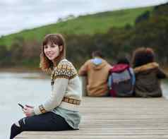 准备好了离开文明肖像年轻的女人手机坐着码头湖