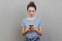 女人持有智能手机打字消息浏览网络沟通细胞电话
