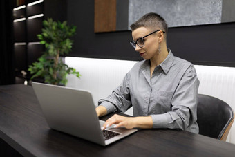 成功的女人程序员工作时尚的办公室移动PC发展中应用程序
