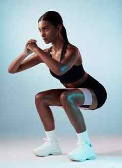 锻炼蹲健身黑色的女人乐队屁股锻炼电阻培训体育健康工作室运动员承诺健康生活方式年轻的模型孤立的蓝色的背景