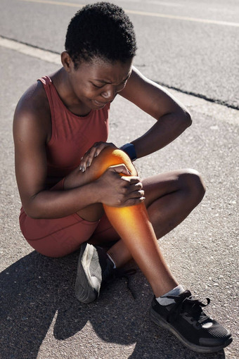健身受伤疼痛体育黑色的女人持有膝盖锻炼锻炼沥青路运行马拉松解剖学受伤的女跑步者运动员运行