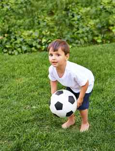 实践可爱的男孩玩足球球