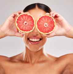 葡萄柚护肤品健康女人持有水果护肤品维生素脸发光模型水果健康化妆品眼睛治疗健康的饮食营养食物美