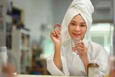 有吸引力的年轻的女人持有药丸玻璃水每天维生素补充皮肤头发指甲加强