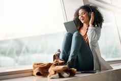 旅行平板电脑音乐耳机黑色的女人流媒体广播播客技术放松快乐女触屏社会媒体应用程序网络互联网浏览机场游说团体