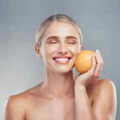 女人微笑橙色水果护肤品美健康灰色工作室背景化妆品模型皮肤脸健康护理维生素化妆品有机皮肤病学