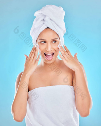 兴奋保湿霜工作室拍摄有吸引力的年轻的女人应用脸保湿霜蓝色的背景