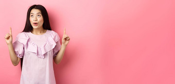 兴奋青少年亚洲女人指出手指梦幻空空间站衣服粉红色的背景