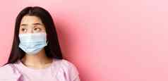 科维德流感大流行检疫概念特写镜头伤心亚洲女孩医疗面具感觉孤独的冠状病毒站粉红色的背景