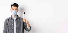 健康的人科维德概念年轻的男人。医疗面具预防措施冠状病毒显示瓶手洗手液站白色背景