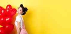 情人节一天的关系概念时尚亚洲女人摆姿势红色的心气球惊喜情人特殊的日期黄色的背景