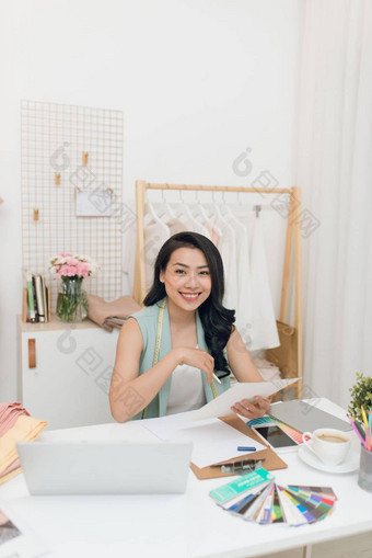 时尚设计师工作快乐年轻的亚洲女人画坐着工作的地方时尚车间