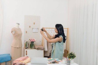 年轻的亚洲女时尚设计师采取测量人体模型工作室