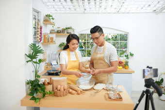 年轻的亚洲夫妇烹饪记录<strong>生活视频视频</strong>博客社会媒体专业相机