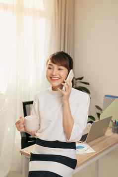 快乐的亚洲女人谈话移动电话德林河咖啡办公室