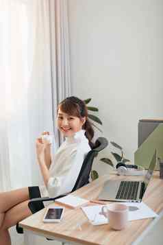 年轻的亚洲女商人吃酸奶放松时间办公室
