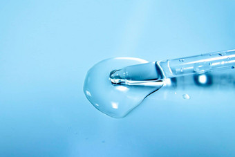 水泡沫化妆品液体滴血清蓝色的背景实验室玻璃吸管特写镜头吸管