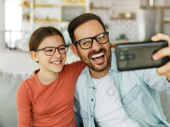 孩子女儿女孩家庭<strong>快乐</strong>父亲肩扛玩有趣的女孩<strong>快乐</strong>的微笑首页室内成键爱自拍相机移动电话智能手机照片<strong>图片</strong>肖像