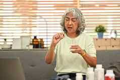 中间岁的女人持有药丸玻璃水上了年纪的医疗保健制药医疗保健治疗概念