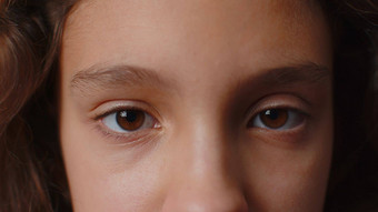 特写镜头宏肖像青少年孩子孩子脸微笑棕色（的）女孩眼睛相机<strong>眨眼眨眼</strong>