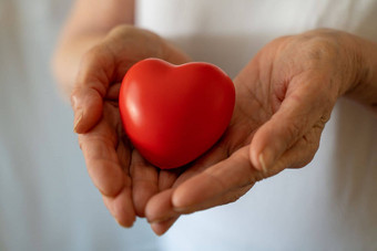 祖母女人手持有红色的心医疗保健爱器官捐赠正念幸福家庭保险企业社会责任概念<strong>世界</strong>心一天<strong>世界</strong>健康一天国家器官捐赠一天