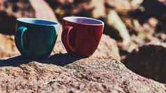 绿色陶瓷杯咖啡茶饮料岩石阳光明媚的石头