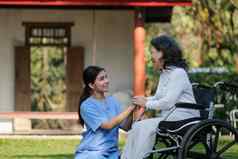 上了年纪的亚洲高级女人轮椅护士护理首页医院花园概念