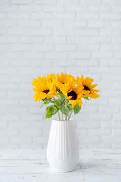 花束向日葵花瓶背景白色砖墙乔皮空间文本