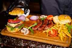 过程烹饪汉堡cropeed视图老板手黑色的手套准备芝士汉堡各种馅料的组成木桌子上餐饮好质量快餐概念