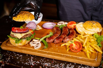 过程烹饪汉堡cropeed视图老板手黑色的手套准备芝士汉堡各种馅<strong>料</strong>的组成木桌子上餐饮好质量快餐概念