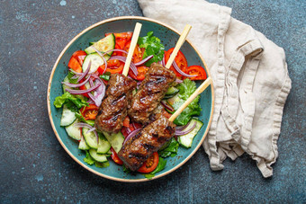 烤串肉扦肉牛肉烤肉串棒服务新鲜的蔬菜沙拉板乡村混凝土背景传统的中间东部土耳其菜烤肉串