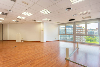空办公室荧光灯天花板修复更换明亮的办公室空间租金光棕色（的）木条镶花之地板大全景窗户空被遗弃的办公室