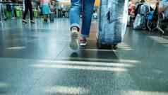 特写镜头回来视图女腿运动鞋女人旅行者乘客包装手提箱行李走大厅机场