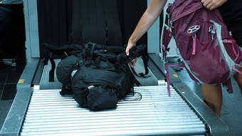 特写镜头乘客袋行李输送机带通过了x射线行李扫描仪检查机场