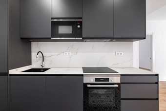现代极简主义厨房灰色的木炭面板白色大理石带概念舒适的时尚的舒适的厨房昂贵的设备