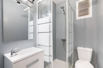 紧凑的现代<strong>浴室</strong>灰色的白色音调<strong>淋浴</strong>玻璃<strong>门</strong>厕所。。。碗水槽内阁存储的事情概念厕所。。。设计的想法紧凑的公寓
