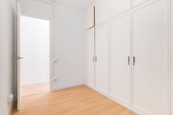 内置的宽敞的衣柜白色镶板通过开放房间木层压板地板概念组织存储<strong>简洁</strong>的室内