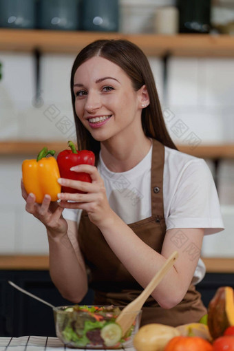 年轻的健康的女人烹饪健康的食物厨房首页健康的生活方式食物饮食概念